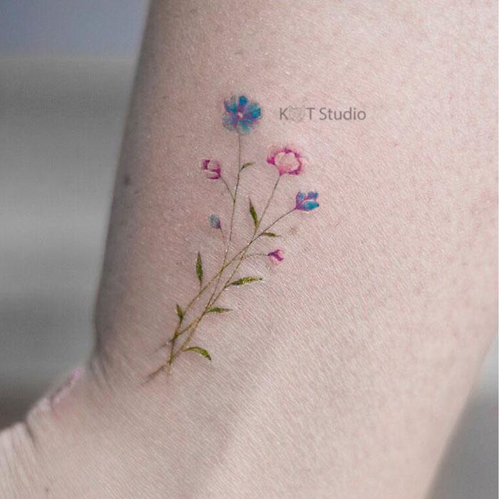 Женское маленькое цветное тату на икре. Татуировка с цветами на лодыжке