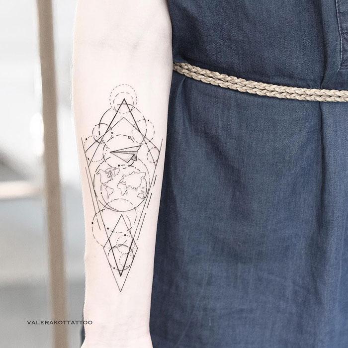 Женское тату на предплечье в стиле геометрия. Татуировка карты и бумажного самолетика для девушек