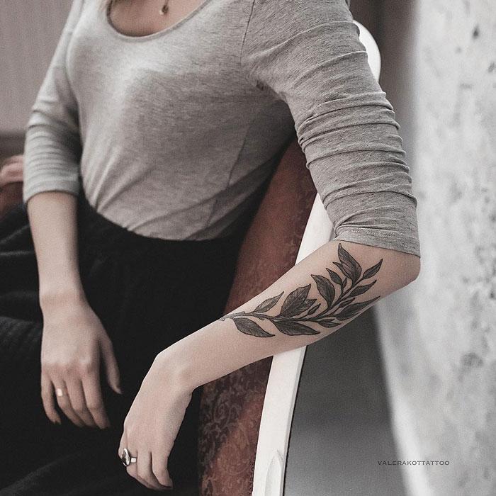 Женское тату на предплечье в стиле графика. Татуировка ветви для девушек