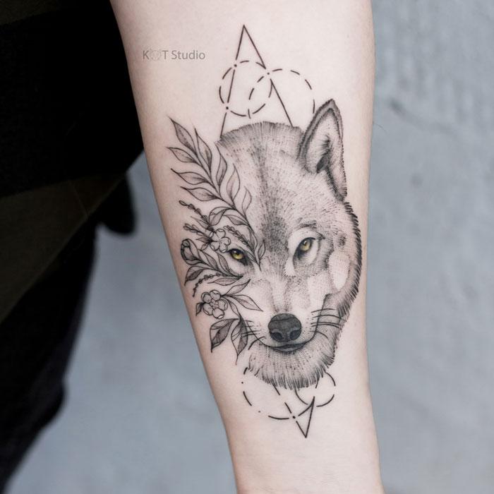 Женское тату на предплечье волк с цветами и элементами геометрии. Татуировка в стиле дотворк, графика, випшейдинг и геометрия